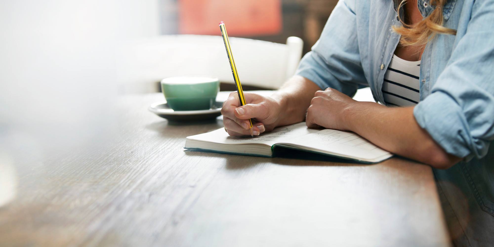 photo of women writing in a notebook. 